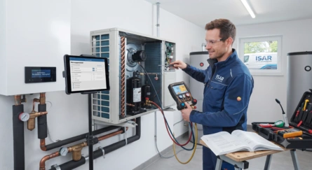 Servicetechniker überprüft eine Wärmepumpe mit Messgerät